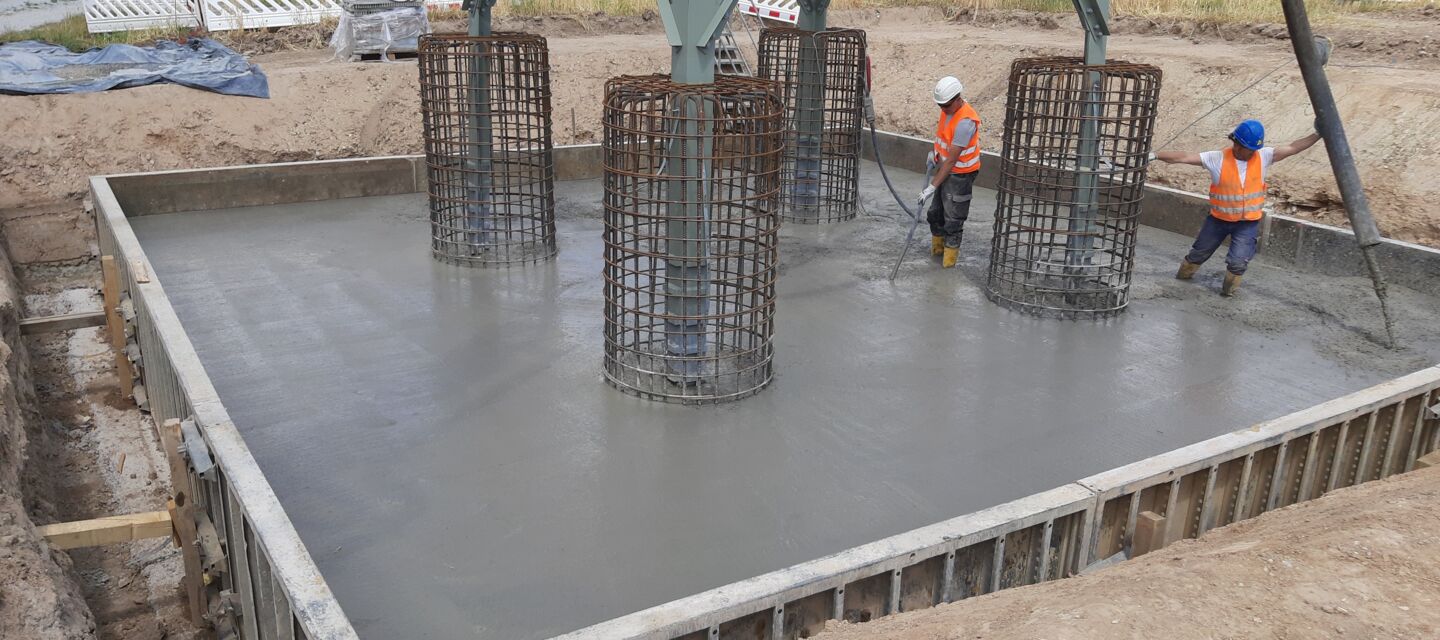 Cteam: Coulage de béton pour les fondations d'un pylône électrique avec des ouvriers. Cteam: Coulage de béton pour les fondations d'un pylône électrique avec des ouvriers.