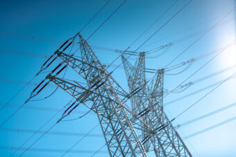 Tours de haute tension Cteam sous un ciel bleu, transportant l'&eacute;nergie.