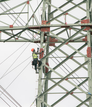 Un travailleur en hauteur sur un pyl&ocirc;ne, un soudeur de Cteam effectuant des travaux de maintenance.