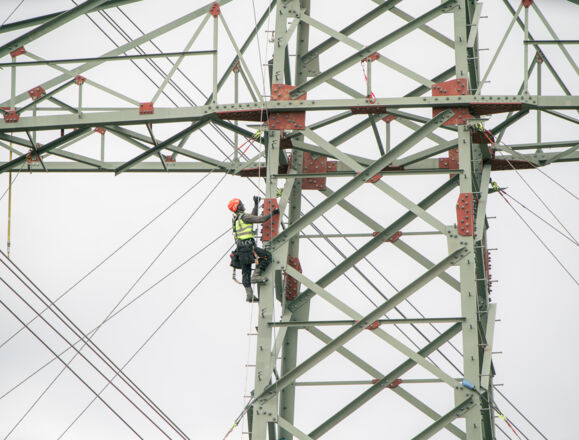 Un travailleur en hauteur sur un pyl&ocirc;ne, un soudeur de Cteam effectuant des travaux de maintenance.