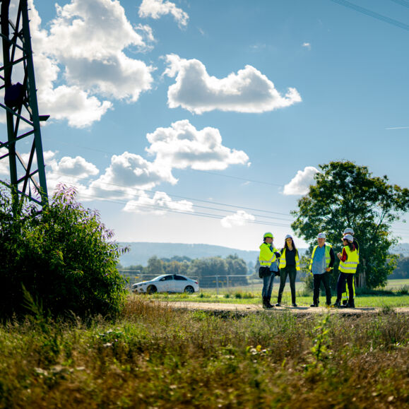 Professionnels Cteam en inspection de site électrique sous un ciel nuageux. Professionnels Cteam en inspection de site électrique sous un ciel nuageux.